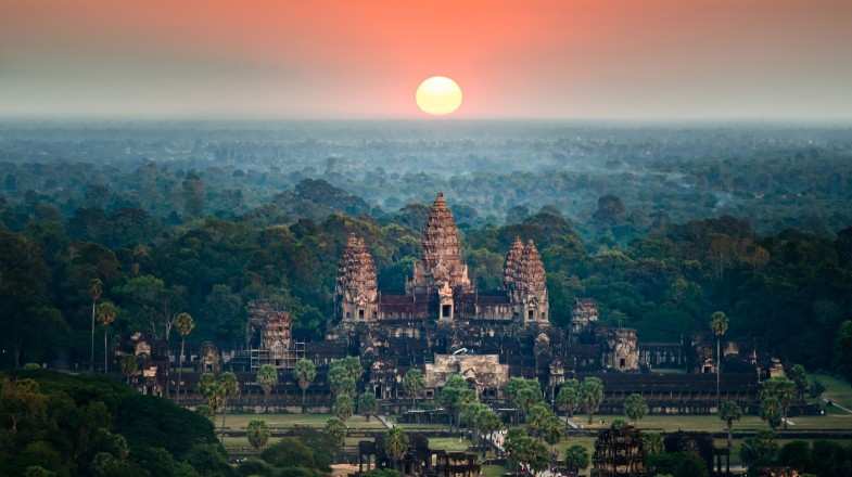 A bird eye view of the Angkor Wat temple surrounded by greenery at sunset in Cambodia in August.