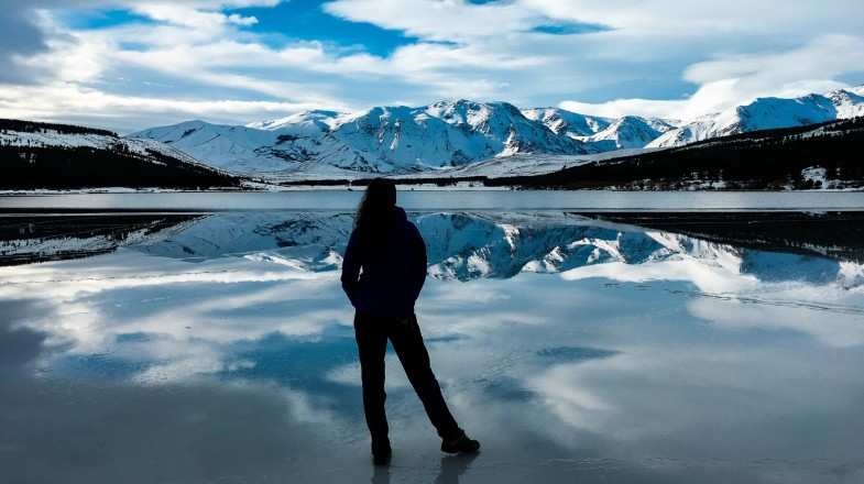 A tourist admires the stunning snowy-mountain scenery during winter in Argentina