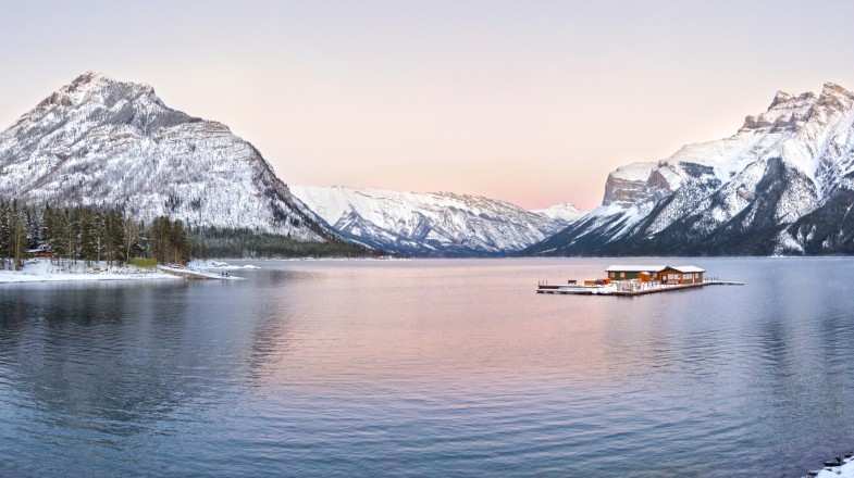 Panoramic view of snowcapped rocky mountains at Lake Minnewanka in Canada.