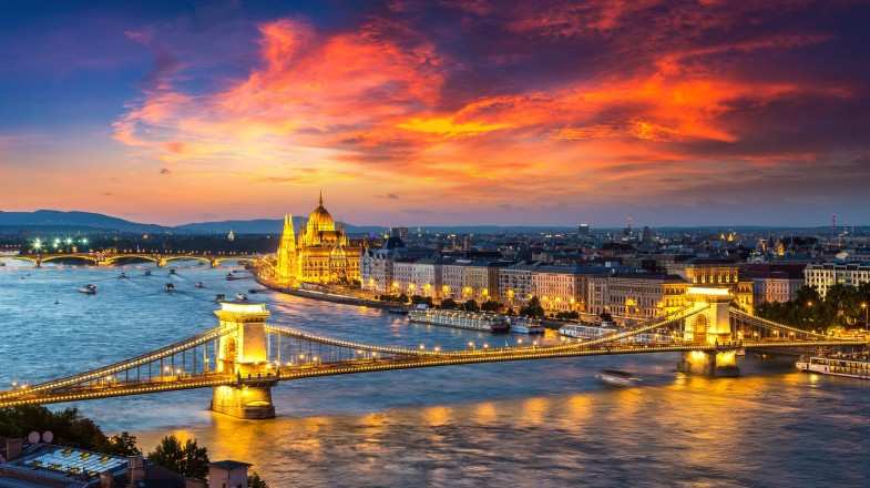 Danube under red sky and brightly lit Budapest city in Hungary in February.