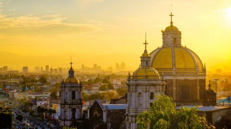 Scenic view at Basilica of Guadalupe with Mexico city skyline at sunset