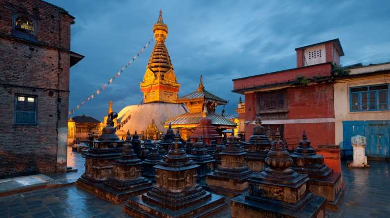 Illuminated Swayambhunath temple against blue sky after rain in Nepal in July.