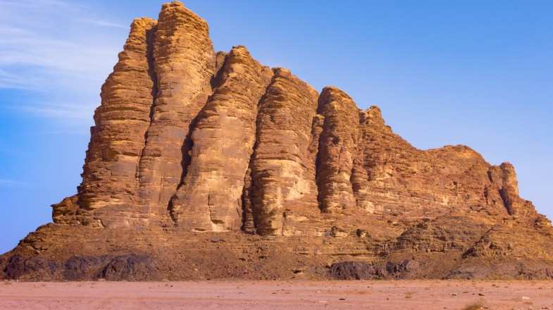 The rust colored Seven Pillars of Wisdom Mountain during summer in Jordan.