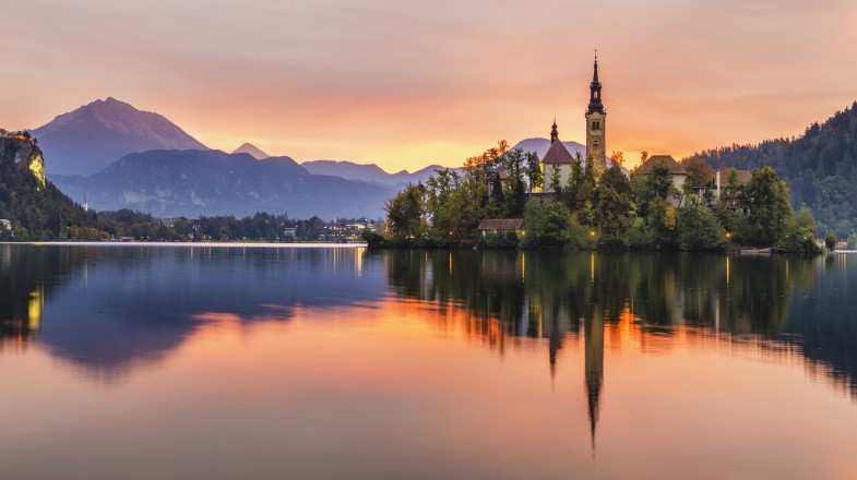 Watch multicolored sunrise over an alpine lake Bled while spending 7 days in Slovenia
