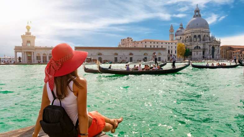 A female tourist looking at Salue and Grand Canal during summer in Italy.