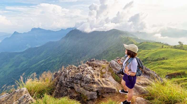 Hiker girl admiring beautiful landscape of nature of mountain range during winter in Thailand.