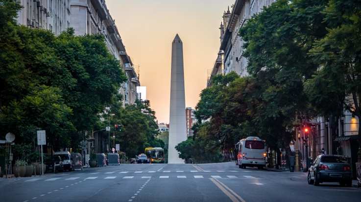 A street lane lined with green trees and Obelisco tower at the end is an iconic site in Buenos Aires — an easy inclusion when spending 10 days in Argentina.