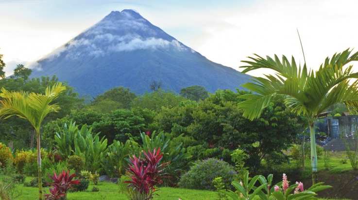 Visit the green park in Costa Rica featuring Arenal Volcano looming in the background on your 7 days in Costa Rica trip.
