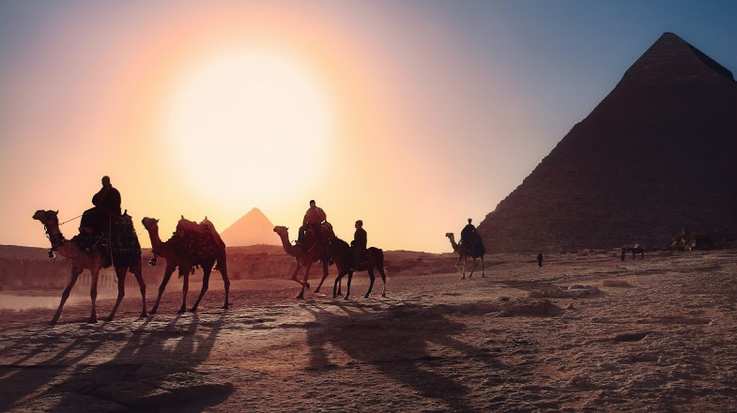 People enjoying camel rides around the pyramids in Egypt during their stay in one week in Egypt.