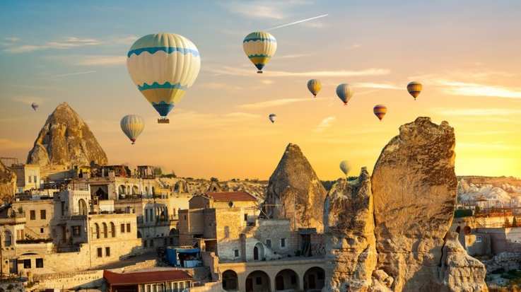 Ride a hot air balloon in Cappadocia in Turkey in July.