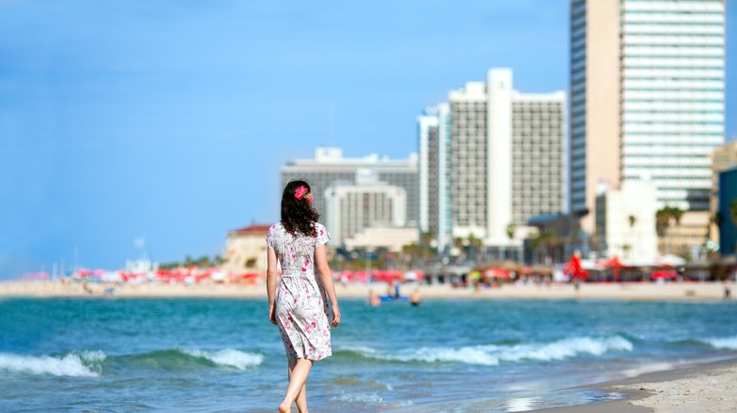 A young girl walking on the beach of Tel Aviv beach in Israel in December.