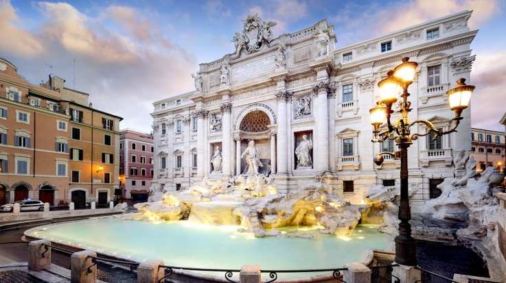 The stunning Trevi fountain in Italy during the evening.