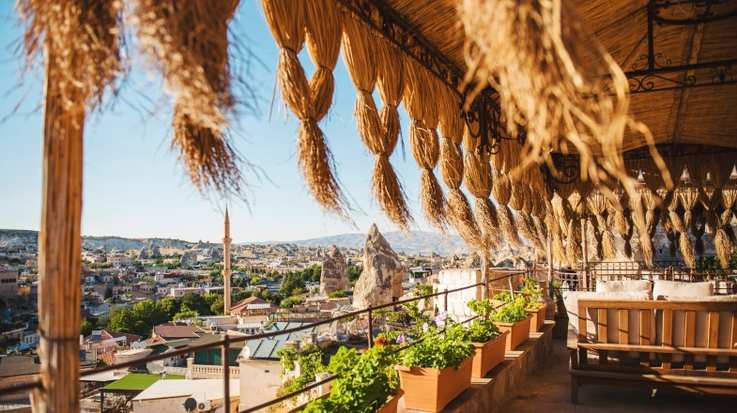 A hotel balcony with a thatched roof you can visit in Turkey in June.