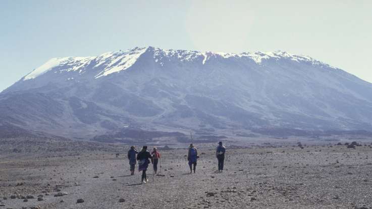 Tourists trekking towards Mount Kilimanjaro