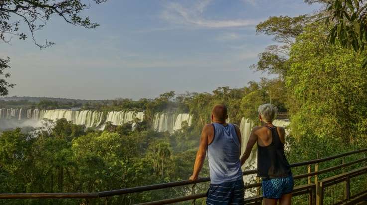 A couple enjoying the beauty of Iguazu falls, Honeymoon in Argentina.