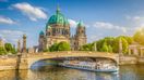 Berlin Cathedral with ship on Spree river at sunset at Berlin in Germany in April.