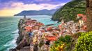 The colorful village of Vernazza and ocean coast in Cinque Terre in Italy on a clear day.