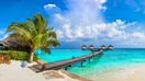 Water Villas and wooden bridge at Tropical beach in Maldives in May.