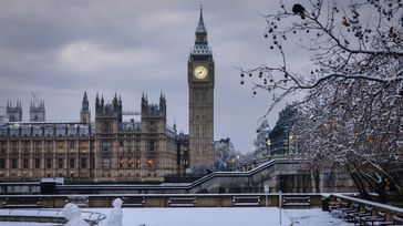 Snowy Big Ben tower against winter sky in England in February.