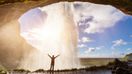 Traveler feeling the power of Seljalandsfoss Waterfall in Iceland