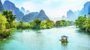 Visitors cruising Li River on a bamboo raft