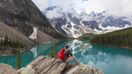 A hiker gazes over Moraine Lake in the Canadian Rockies, a must-add destination to any Canada itinerary.