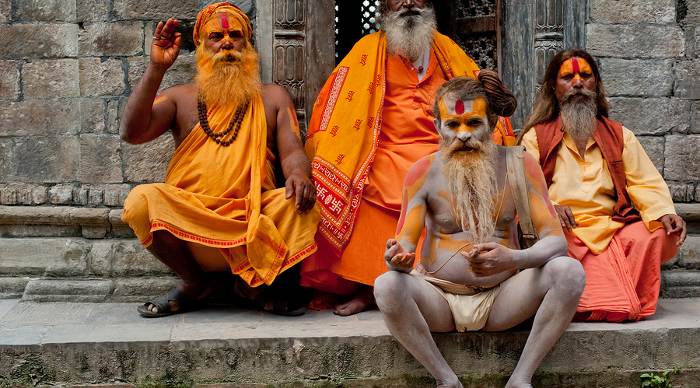 Holy Sadhu men with traditional painted face blessing in Pashupatinath Temple. 