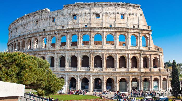 Tourists visiting the Colosseum. The Colosseum is an iconic symbol of Imperial Rome. It is one of Rome's most popular tourist attractions in Rome.