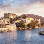 Lake Pichola with City Palace view at cloudy sunset sky in Udaipur Rajasthan India