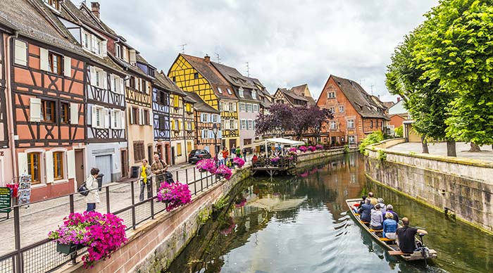People enjoying a boat ride in the canals of Colmar in France