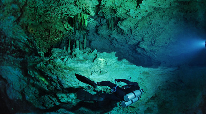 A lonely diver is swimming along the cave wall in Kukulkan cave Yucatan peninsula Mexico
