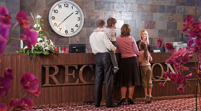 Family talking with a receptionist of the hotel