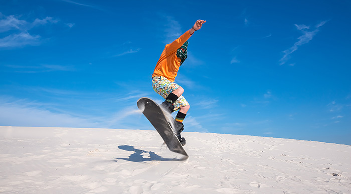 Snowboarder wearing a scarf to protect against sand while in Sahara desert