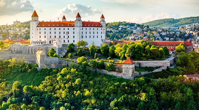 View on Bratislava castle on the green hill from the modern bridge on the sunset in Slovakia