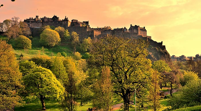View of Edinburgh Castle and Princes Street Gardens at sunset