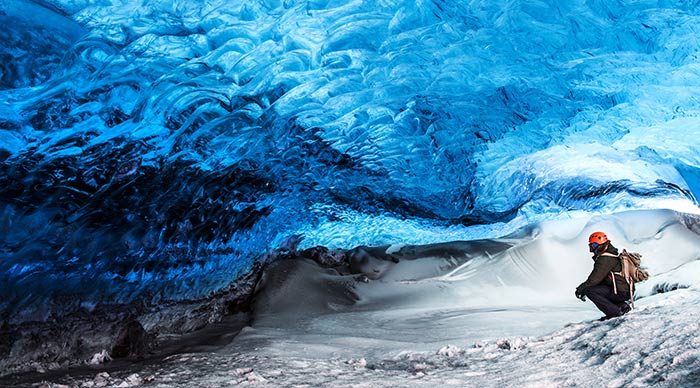 Traveler sitting in the ice cave of Skaftafell glacier