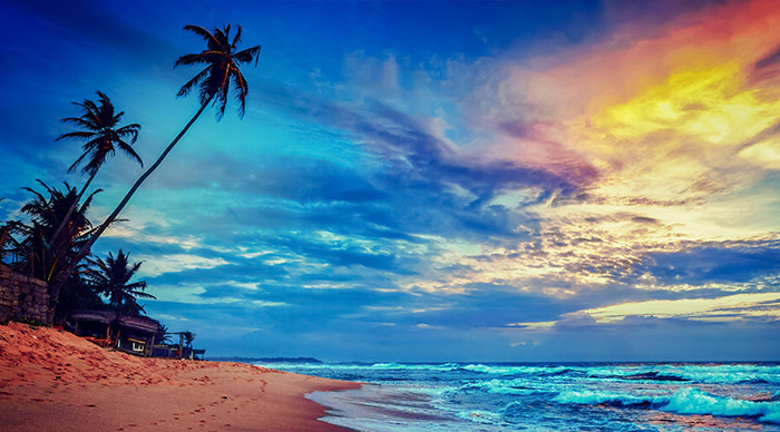 Image of sunset on tropical beach with dramatic cloud sky in Sri Lanka