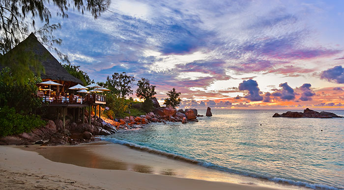 Cafe on Seychelles tropical beach at sunset